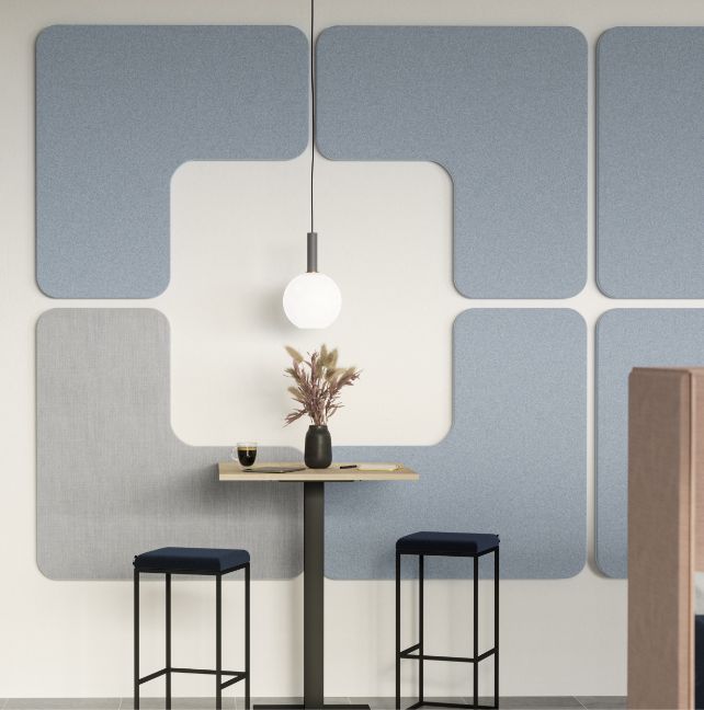 Zwei Hocker vor einer Wand mit Akustikpaneelen