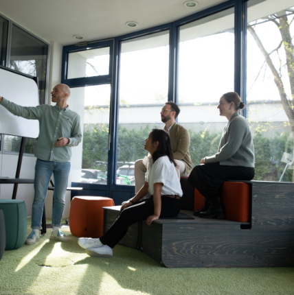 Drei Personen sehen sich eine Präsentation an