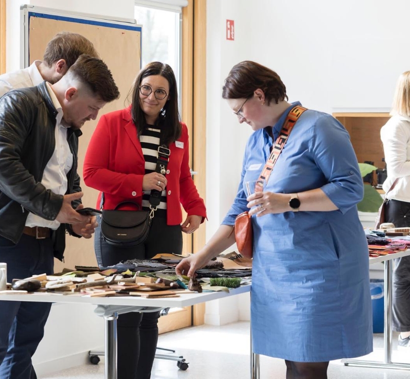 Mehrere Personen sehen sich Materialmuster an