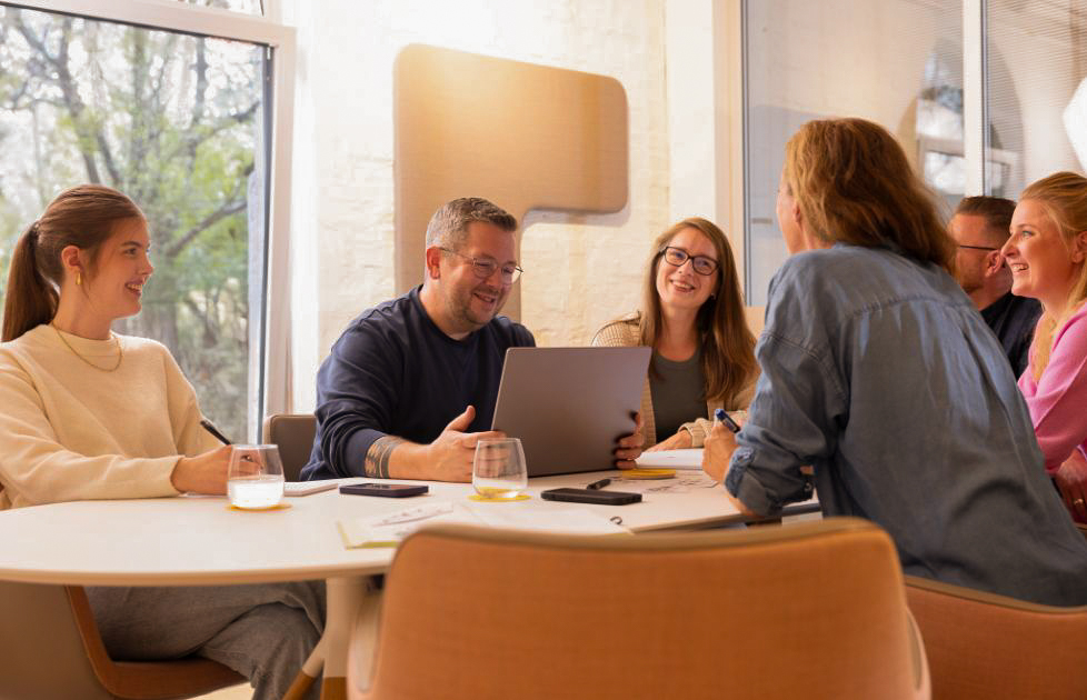 Zufriedene Mitarbeiter am Besprechungstisch