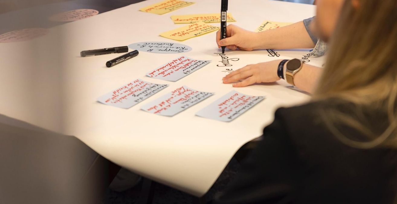 Person schreibt etwas auf ein Plakat